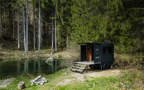 Un sauna dans la forêt à côté d'un petit lac.