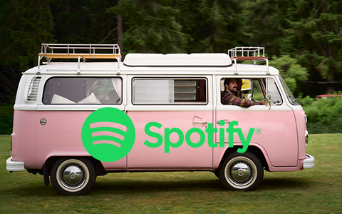 Ein rosaroter VW Bus fährt auf einem Campingplatz.