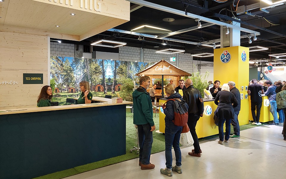 Des invités se font conseiller sur un stand d'exposition.
