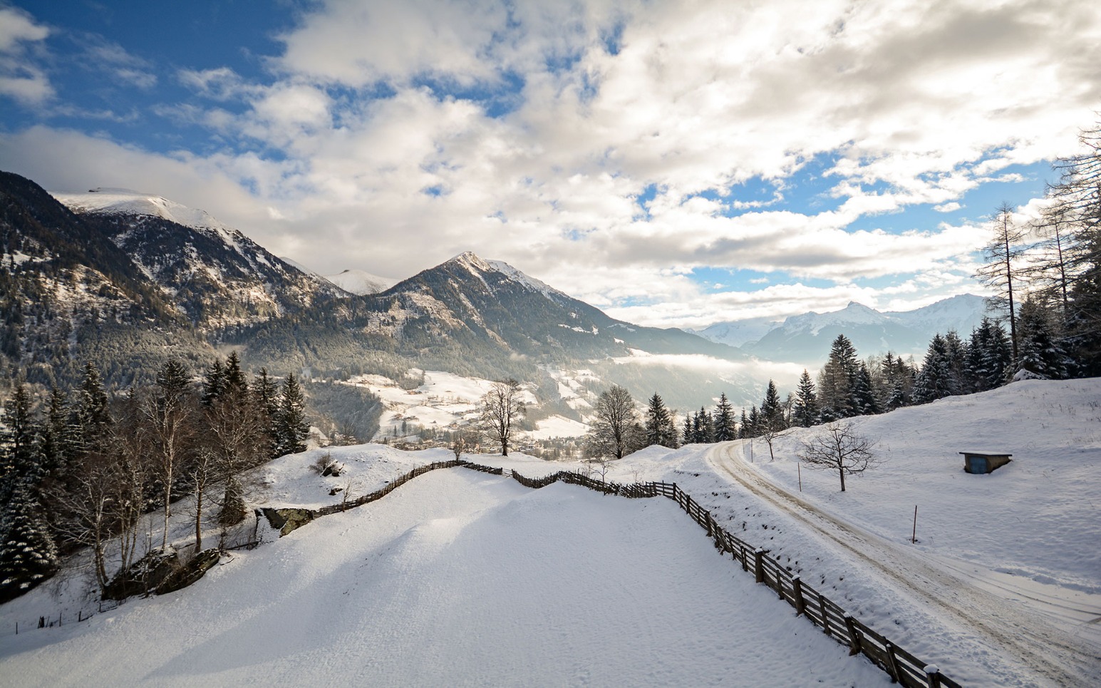 Una strada innevata nel mezzo di un paesaggio montano.